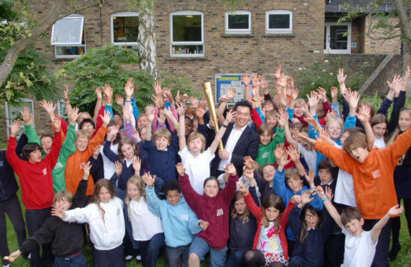 Alan Mak with the Olympic Torch at a school talk 