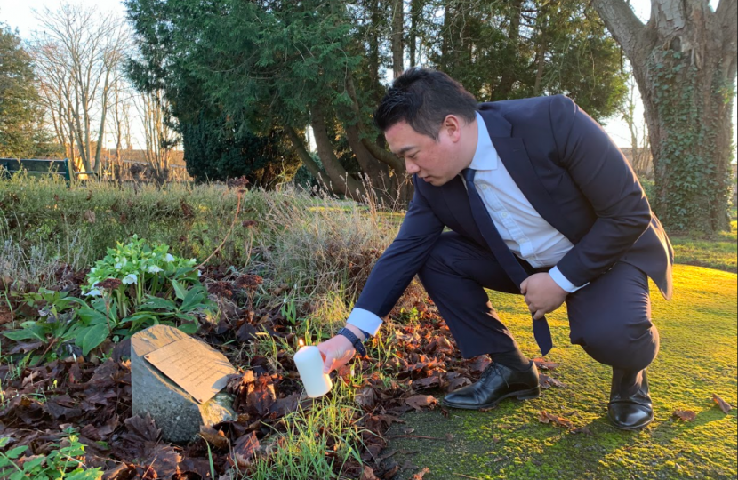 Local MP Alan Mak lights a candle at the Havant cemetery, pausing to remember victims of the Holocaust and other genocides