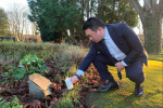 Local MP Alan Mak lights a candle at the Havant cemetery, pausing to remember victims of the Holocaust and other genocides