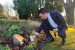 Local MP Alan Mak lights a candle at the Havant cemetery, pausing to remember victims of the Holocaust and other genocides